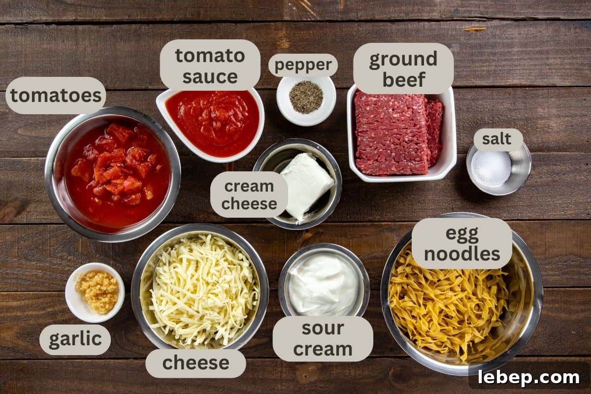 Creamy Sour Cream Noodle Casserole with Cheese and Herbs 3 Ingredients measured out in individual containers on wooden counter top,