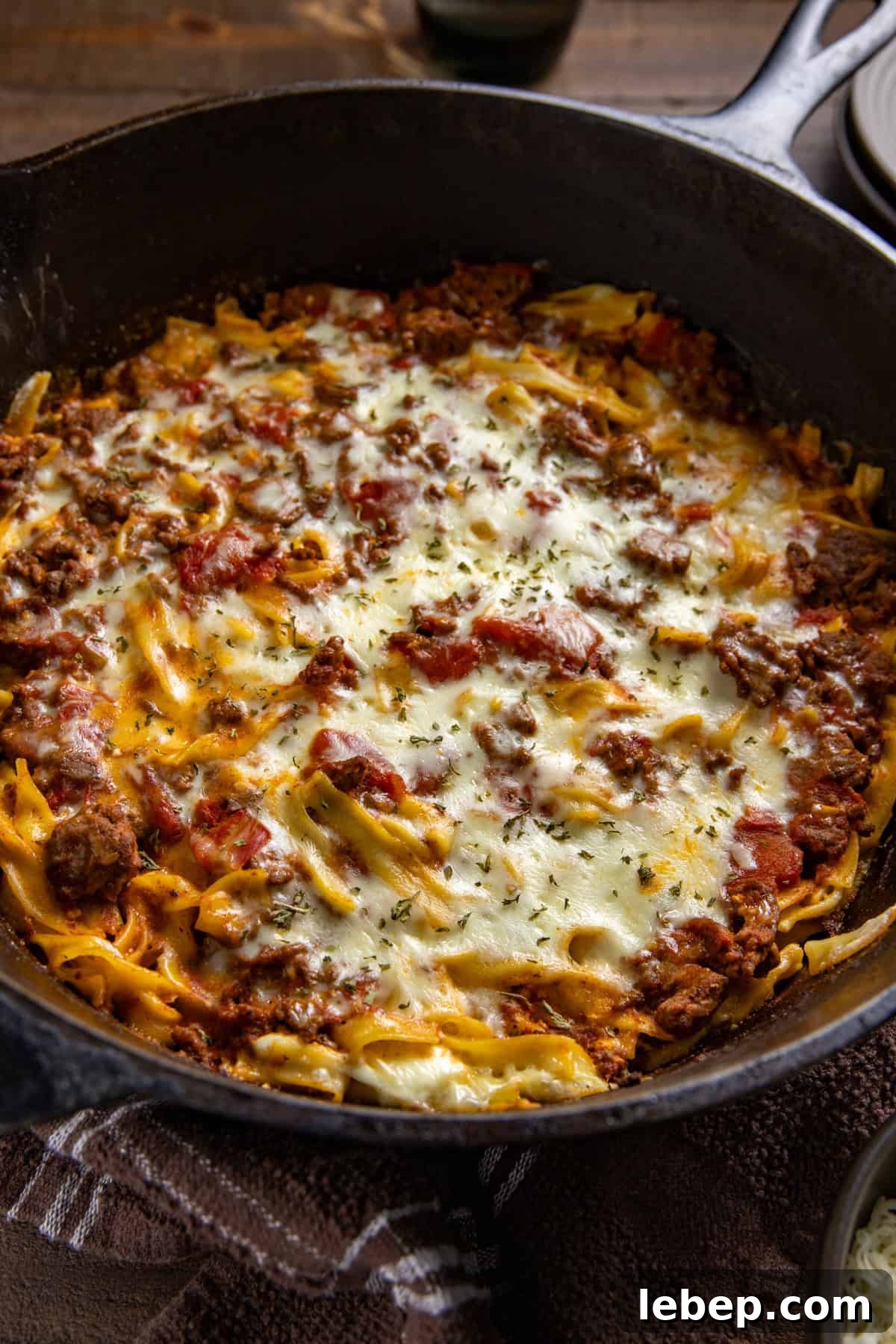Creamy Sour Cream Noodle Casserole with Cheese and Herbs 6 Baked beef and noodle casserole in a cast iron skillet.