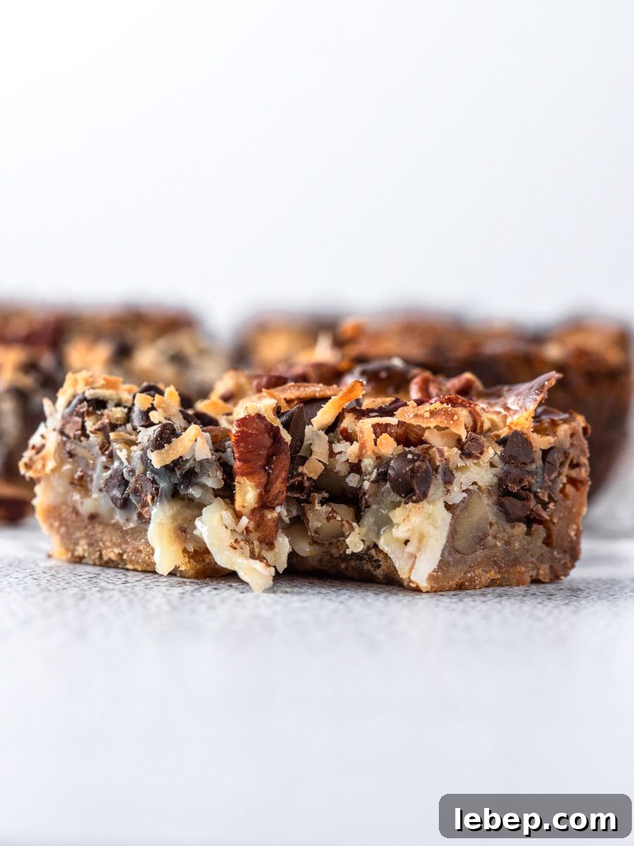 Coconut Magic Bars Recipe: Chewy Coconut Carmel Bars 7 side view shot of the bar showing the inside after a bite
