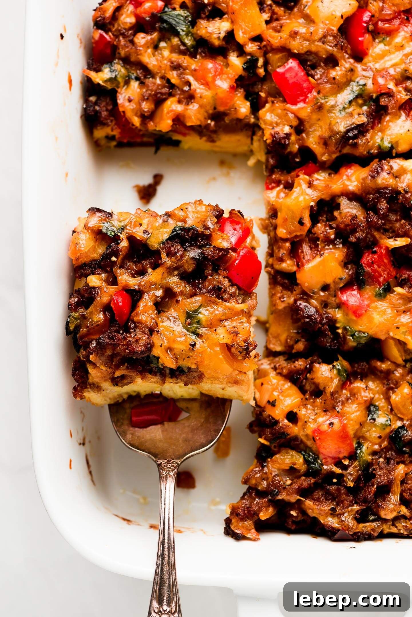 Lifting an egg and sausage breakfast casserole out of baking dish.