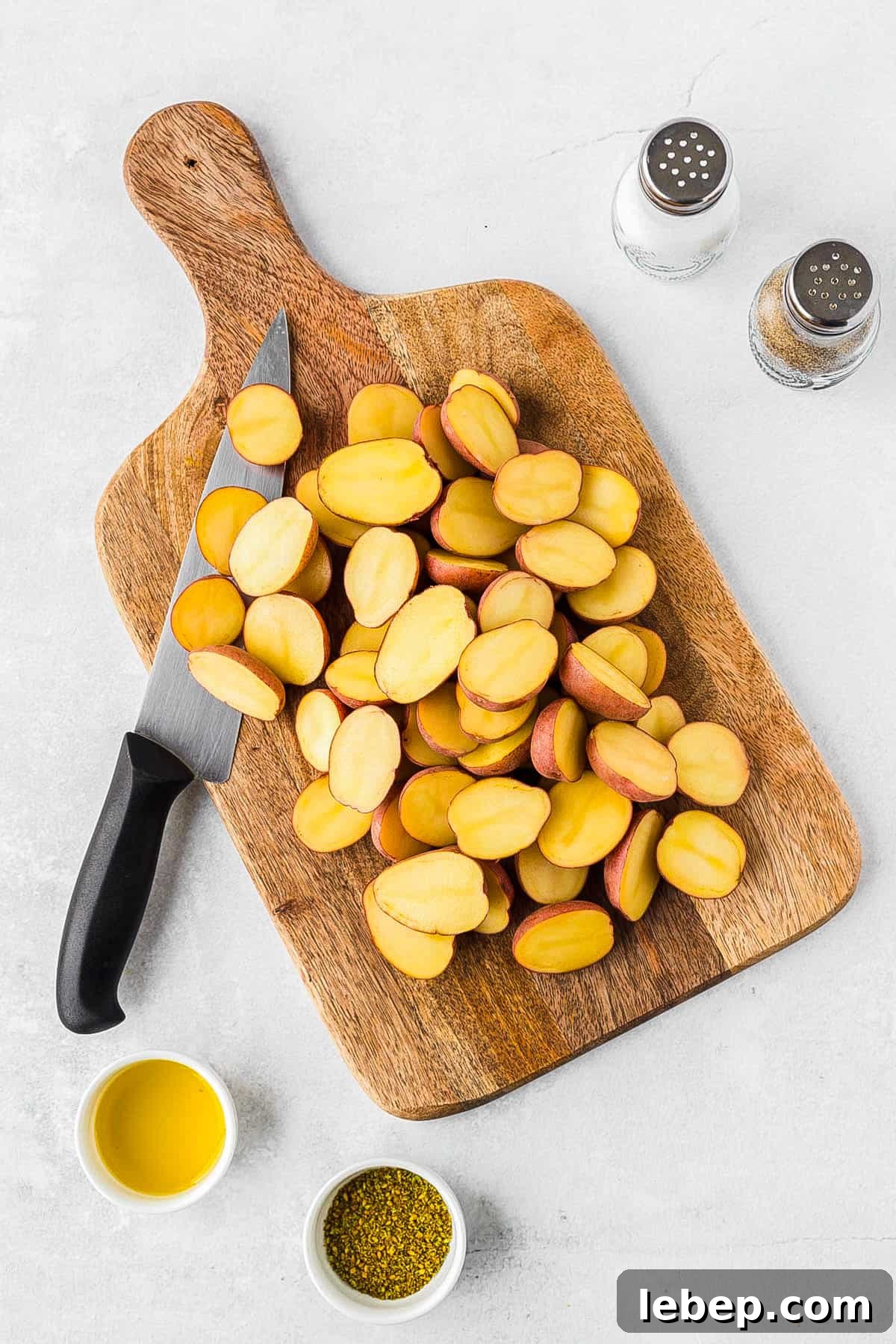Crispy Air-Fryer Red Potatoes Recipe for Perfectly Roasted Sides 4 Sliced red potatoes on a cutting board.