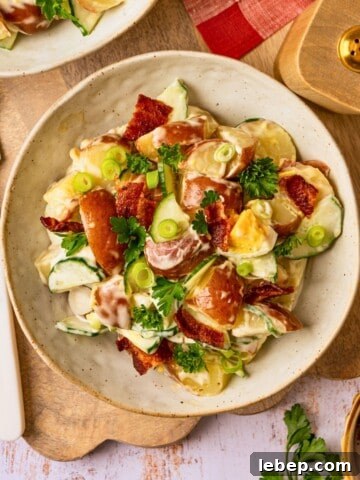 A bowl of potato salad garnished with fresh parsley and chopped green onion.