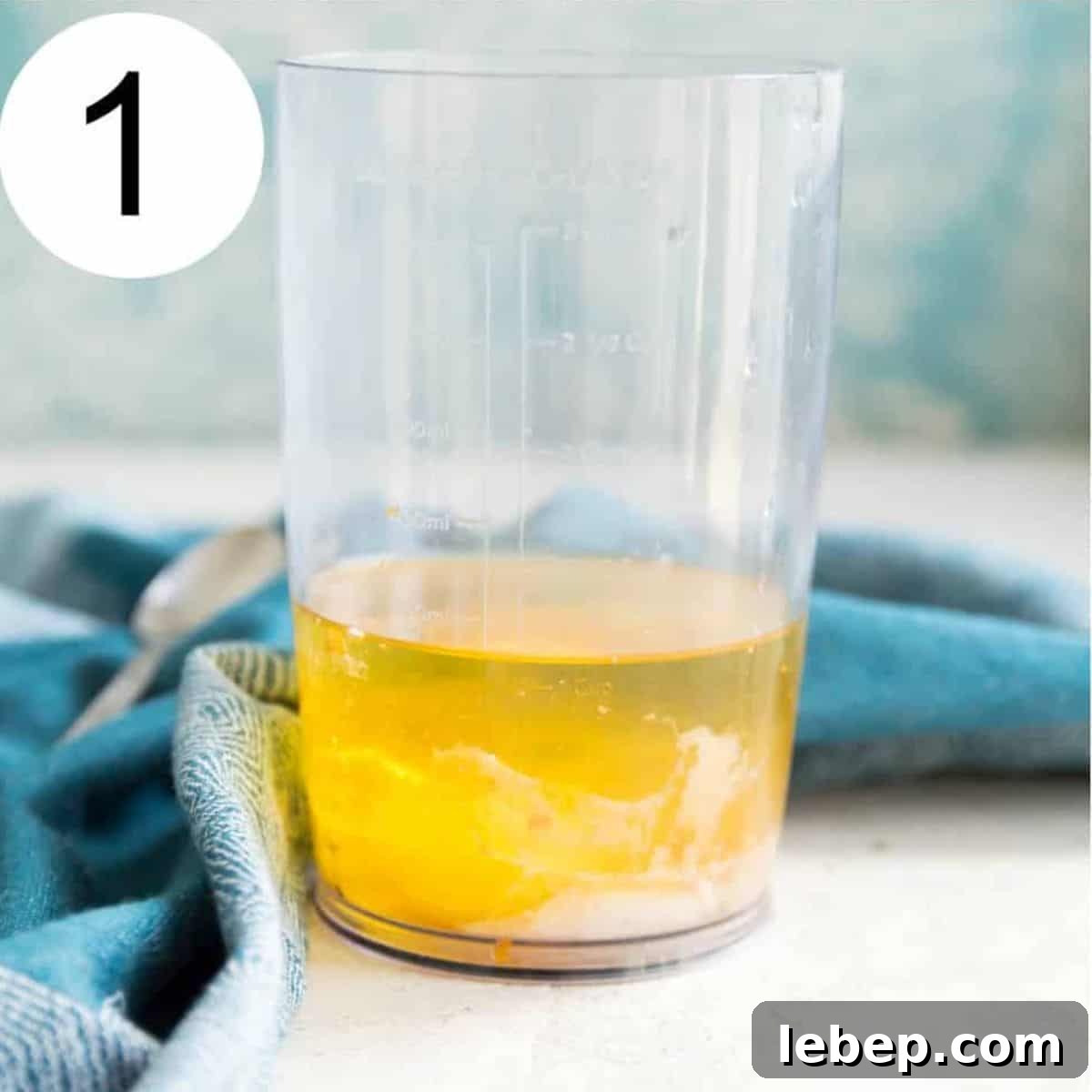 Creamy Immersion Blender Mayonnaise Recipe in Minutes 4 A clear jar with oil and vinegar in it.