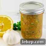 Zesty Homemade Italian Dressing Recipe for Fresh, Tangy Flavor 7 mason jar of Homemade Zesty Italian Dressing with a lemon, garlic, and parsley