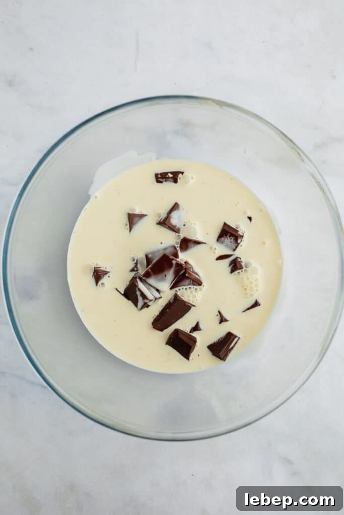 Decadent Tiramisu Layer Cake Recipe for Coffee Lovers 12 A glass bowl with chopped chocolate and heavy cream