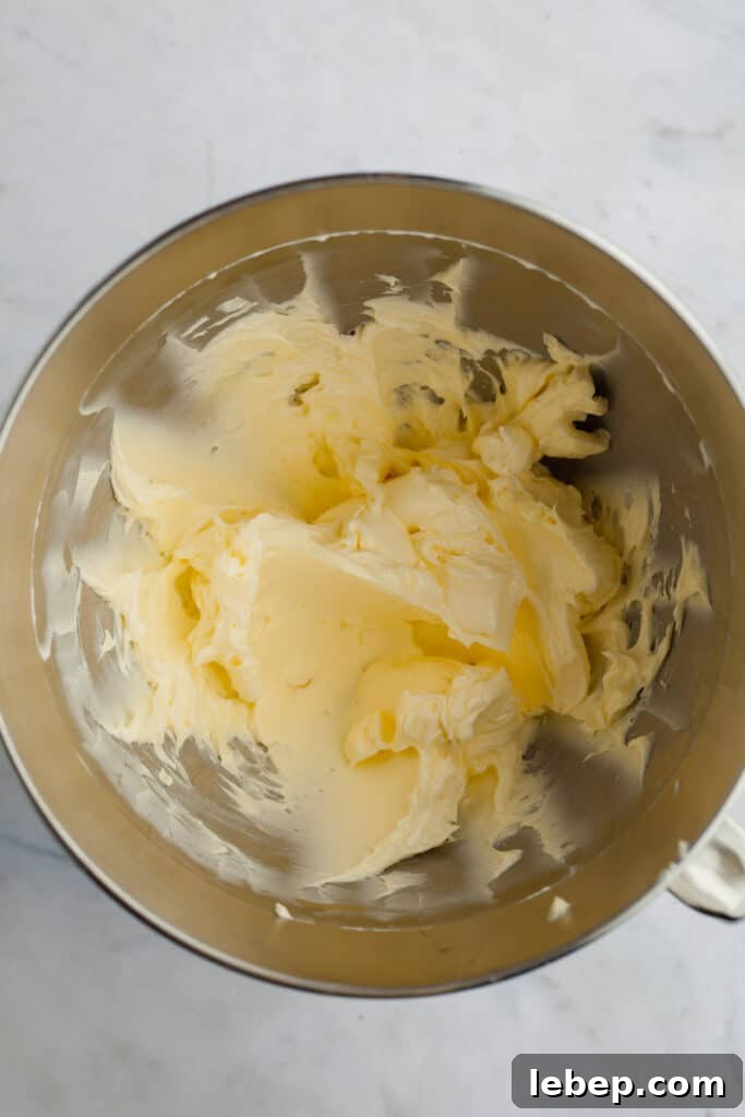 Decadent Tiramisu Layer Cake Recipe for Coffee Lovers 13 A metal mixing bowl with whipped butter and mascarpone