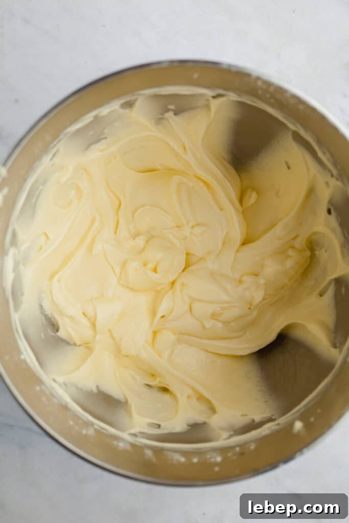 Decadent Tiramisu Layer Cake Recipe for Coffee Lovers 14 A silver mixing bowl with mascarpone buttercream