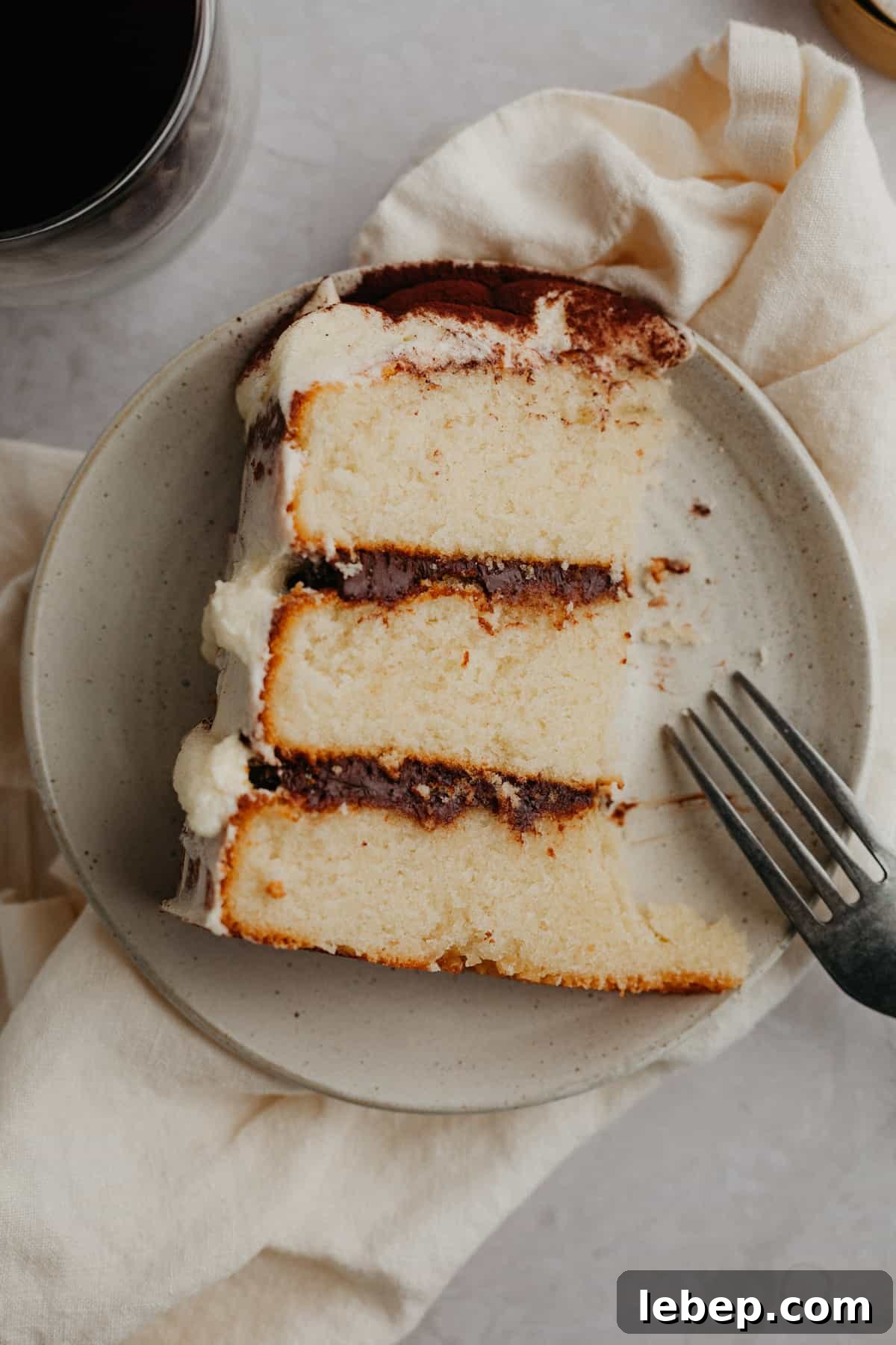 Decadent Tiramisu Layer Cake Recipe for Coffee Lovers 15 A slice of tiramisu cake on a small beige plate