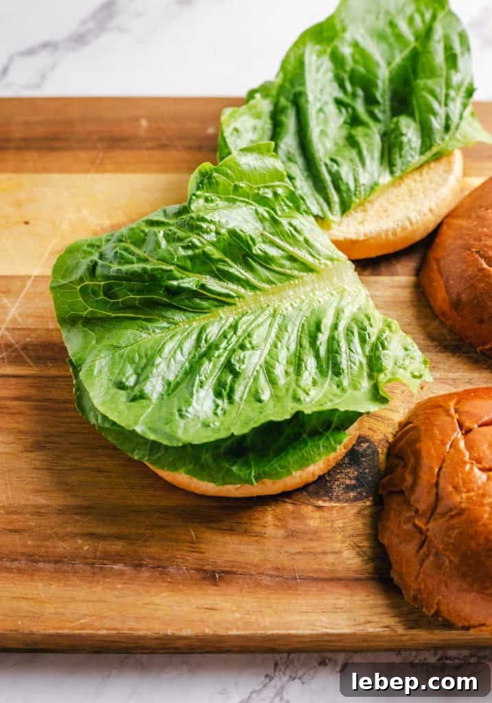 Crispy Fried Chicken Sandwich Recipe with Tangy Slaw 12 Lettuce added to a bun.