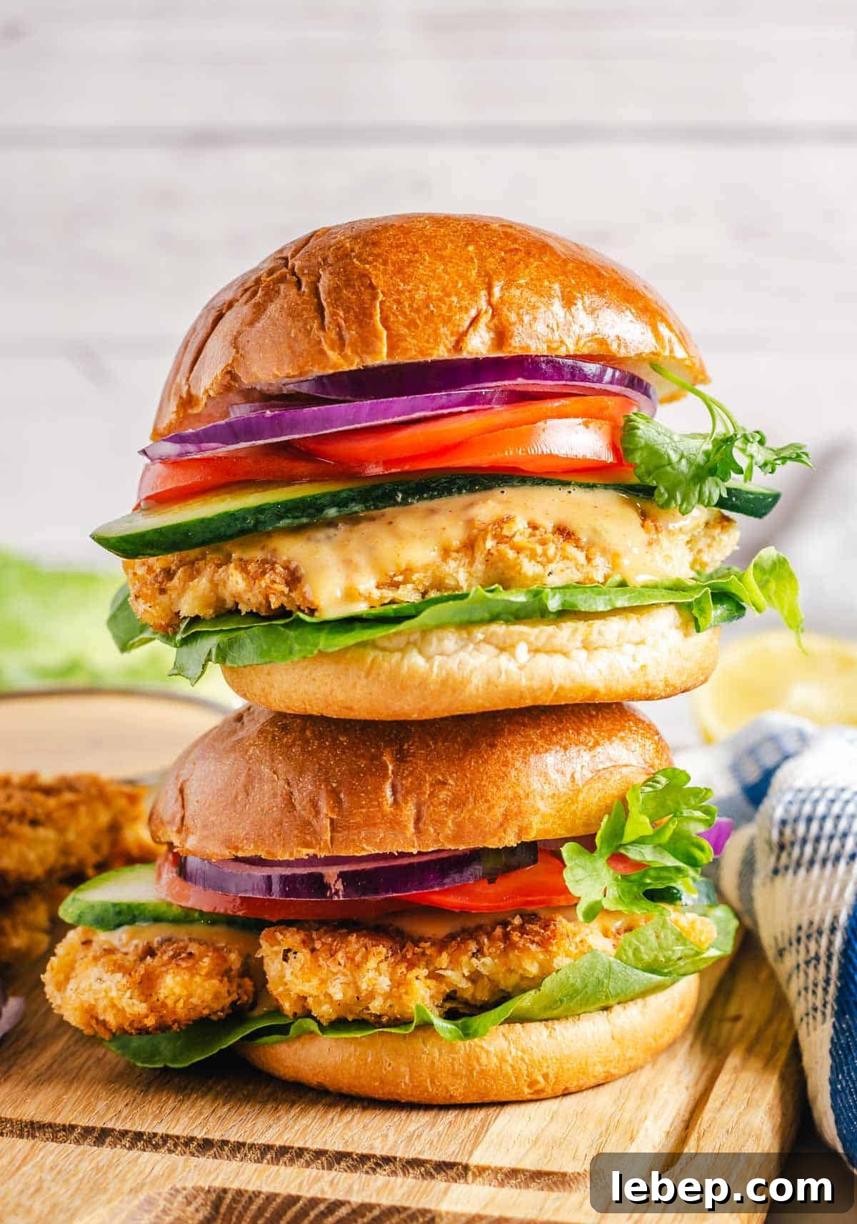Crispy Fried Chicken Sandwich Recipe with Tangy Slaw 17 Two crispy chicken sandwiches stacked on top of each other.