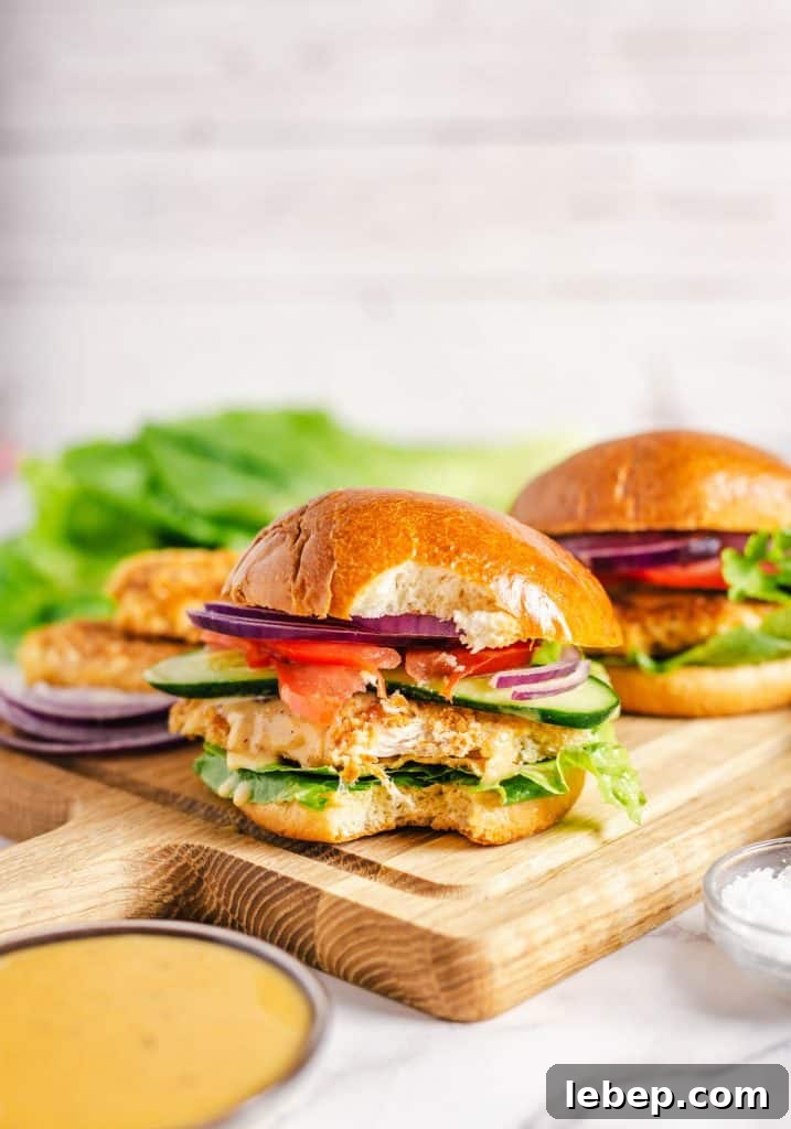 Crispy Fried Chicken Sandwich Recipe with Tangy Slaw 18 Two crispy chicken sandwich with a bite taken out of one.