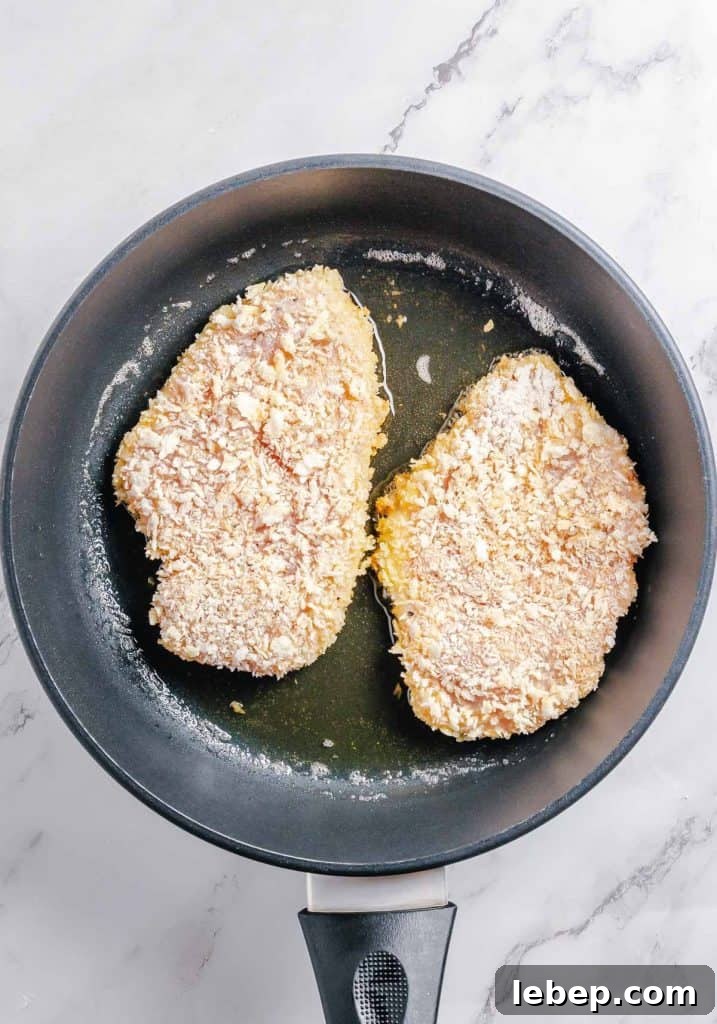 Crispy Fried Chicken Sandwich Recipe with Tangy Slaw 9 Chicken cutlets fried in a pan.