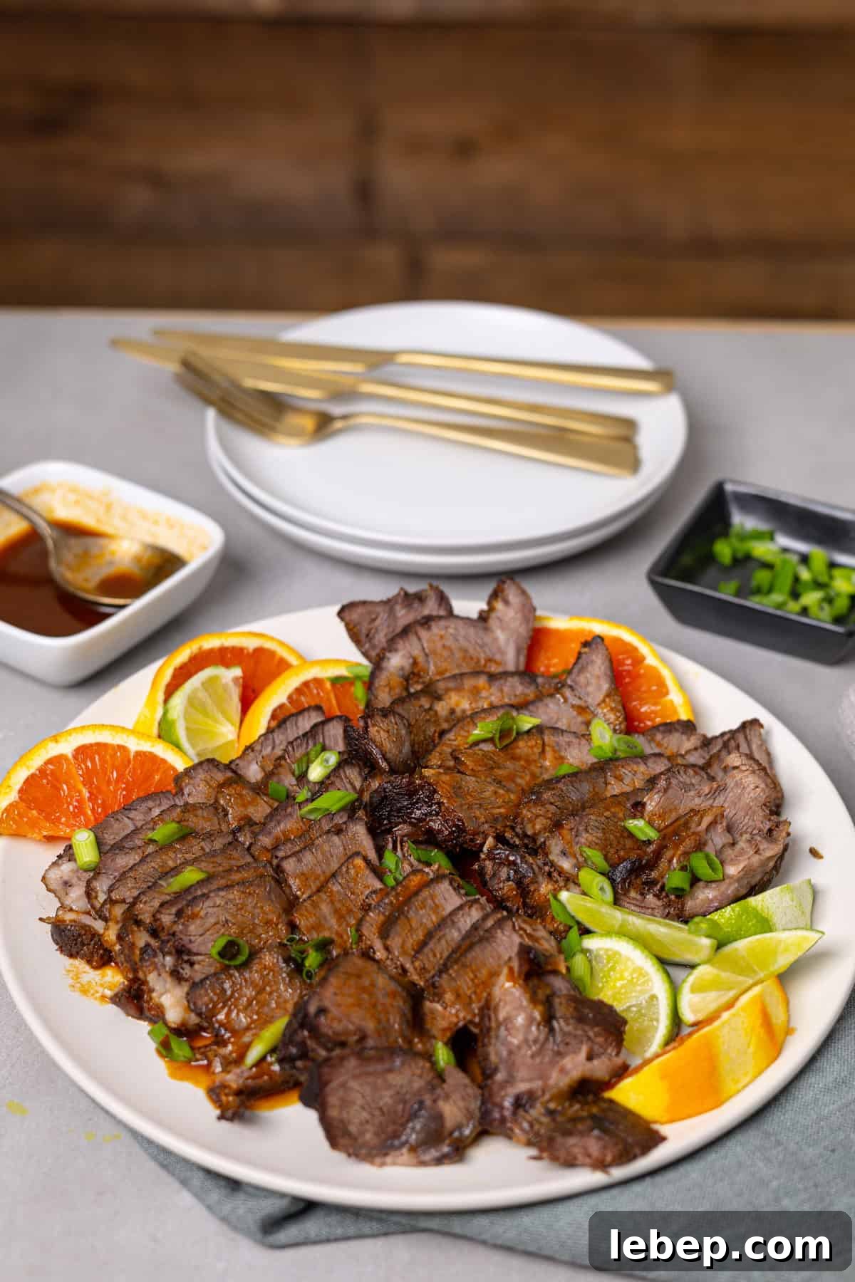 Citrus-Soy Braised Chuck Roast Recipe: Tender, Flavorful Pot Roast 10 A platter of braised chuck roast with citrus on a grey table.