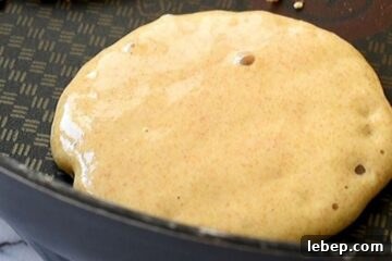 Fluffy Whole Wheat Pancakes with Maple Syrup Recipe 7 Whole Wheat pancake in griddle with small bubbles
