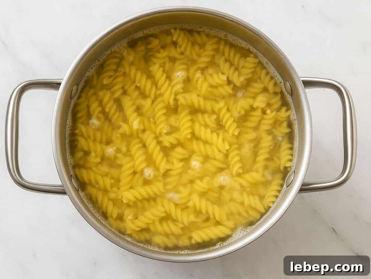 Fusilli pasta boiling in salted water in large pot.