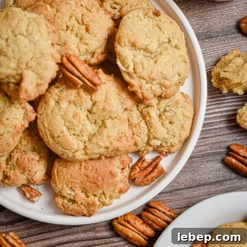 Chewy Coconut Pecan Cookies Recipe — Crispy Edges & Gooey Center 12 Two plates of coconut pecan cookies are surrounded by pecan halves.