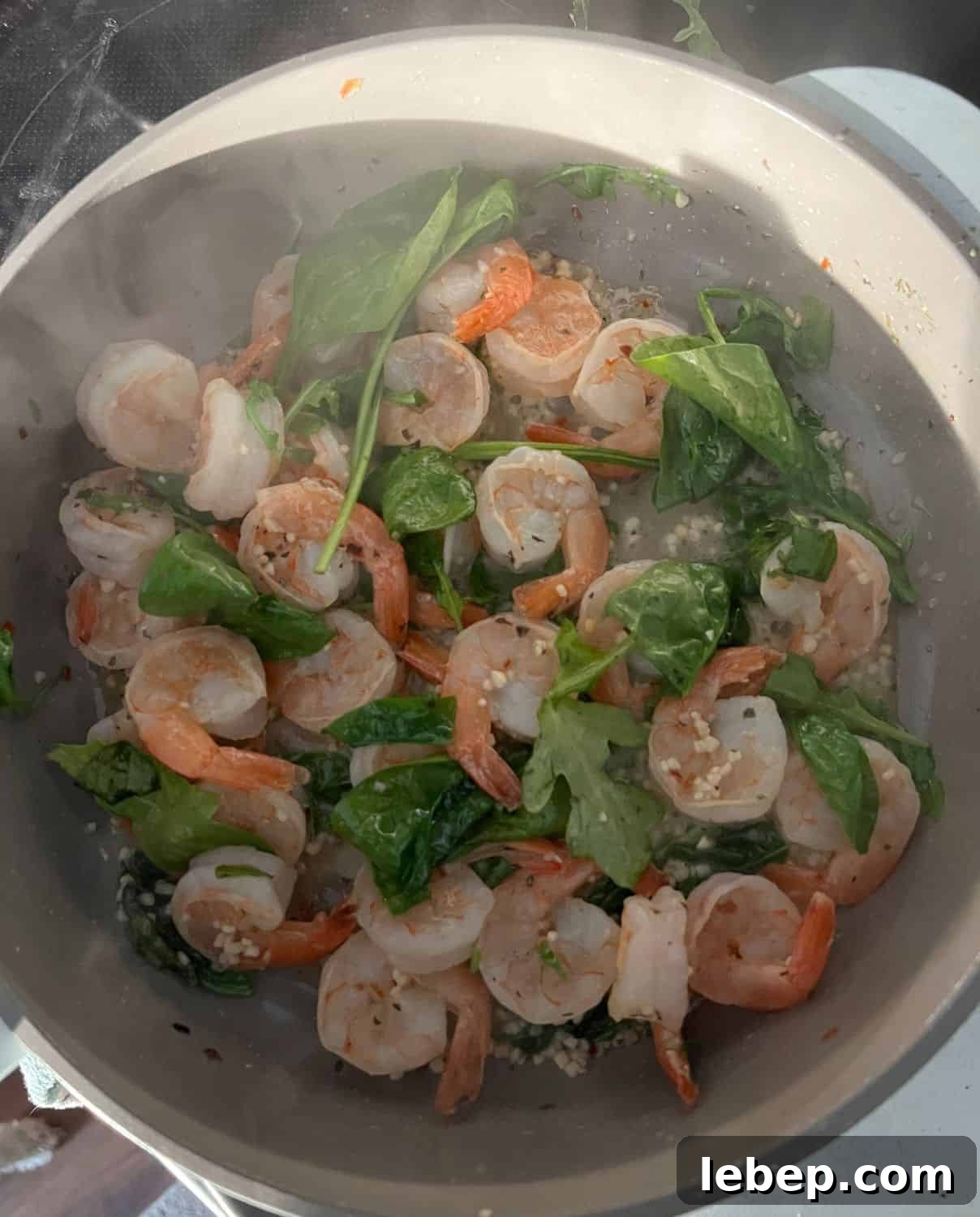 One-Pot Lemon Garlic Shrimp Pasta Recipe 6 Spinach and shrimp cooked in a skillet.