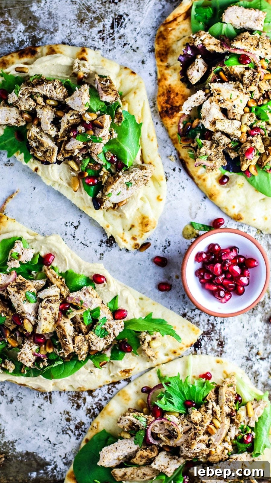 Sheet-Pan Za'atar Chicken on Naan: Quick Flavorful Dinner 6 Naan breads topped with hummus, chicken, and greens.