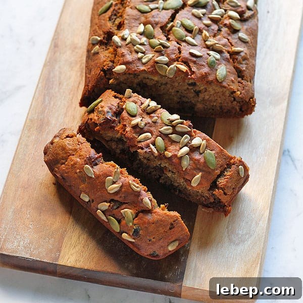 a date loaf sliced on a wooden cutting board
