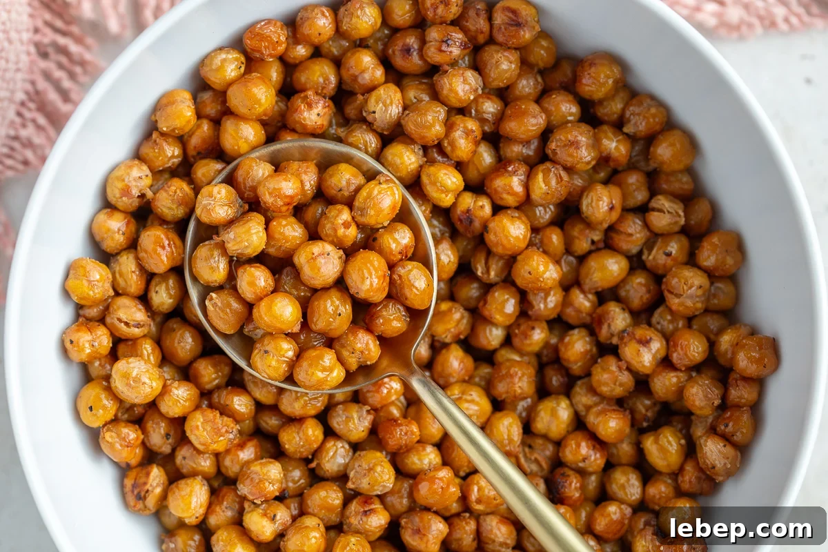 crispy roasted chickpeas in a large white bowl with a big gold spoon in the bowl