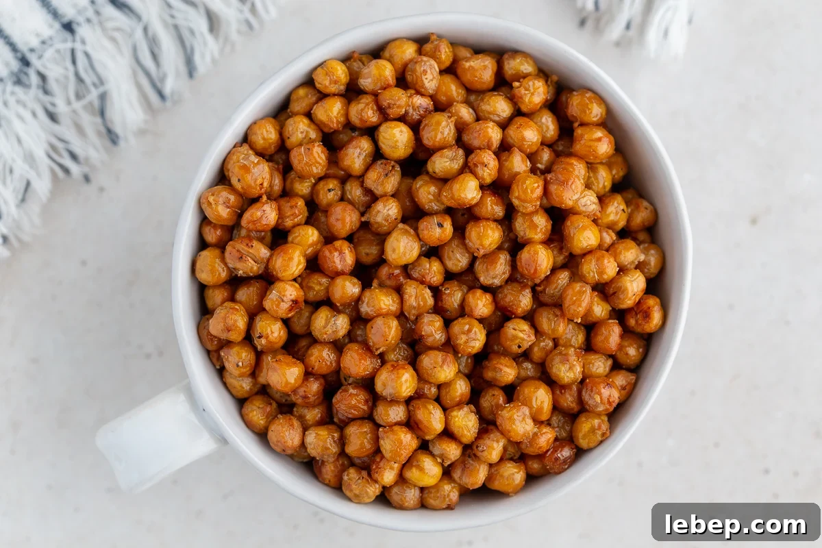 crispy roasted chickpeas in a large white bowl with a big gold spoon in the bowl