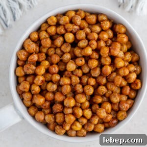 crispy roasted chickpeas in a large white bowl with a big gold spoon in the bowl