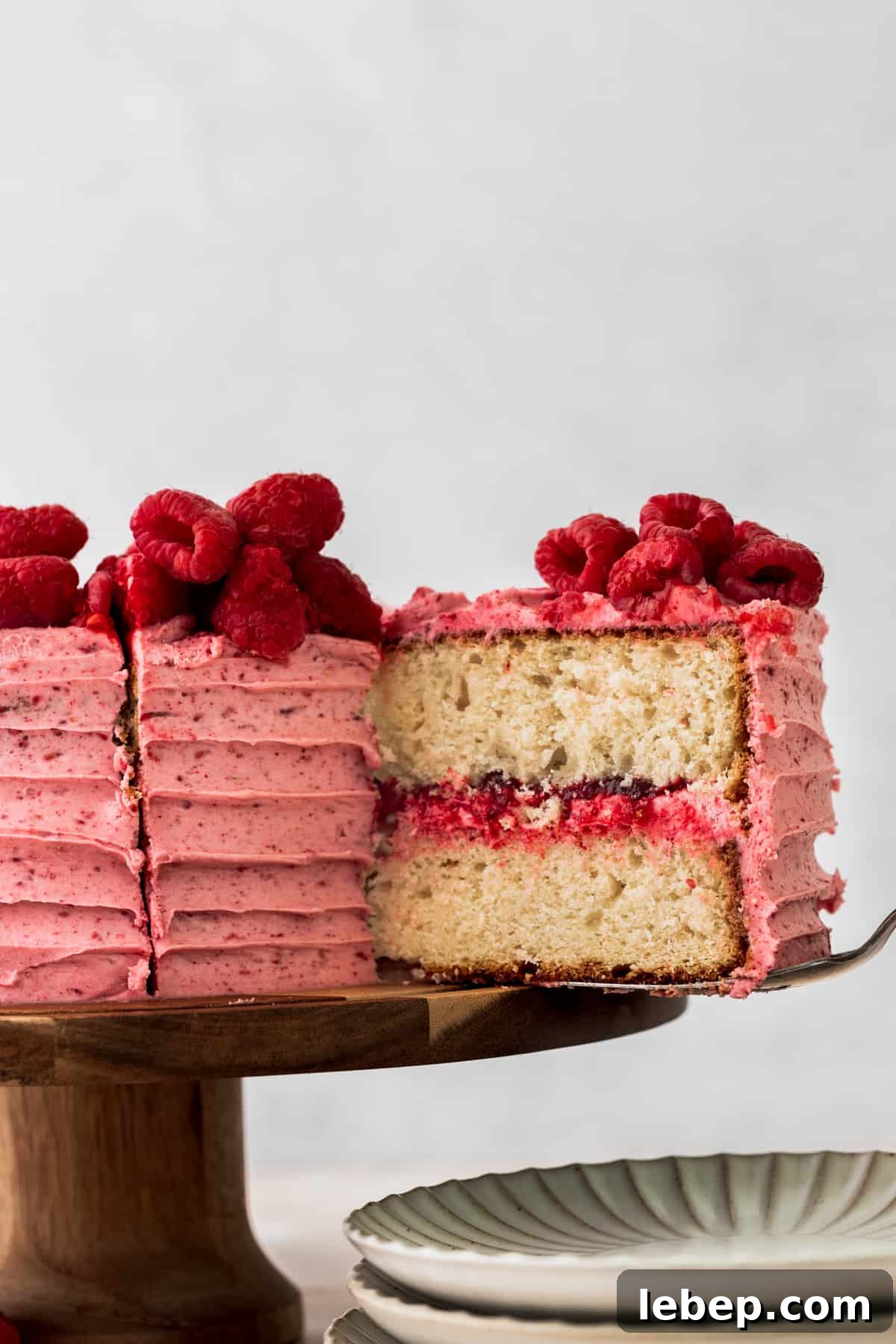 Taking one slice out of the vanilla raspberry cake.