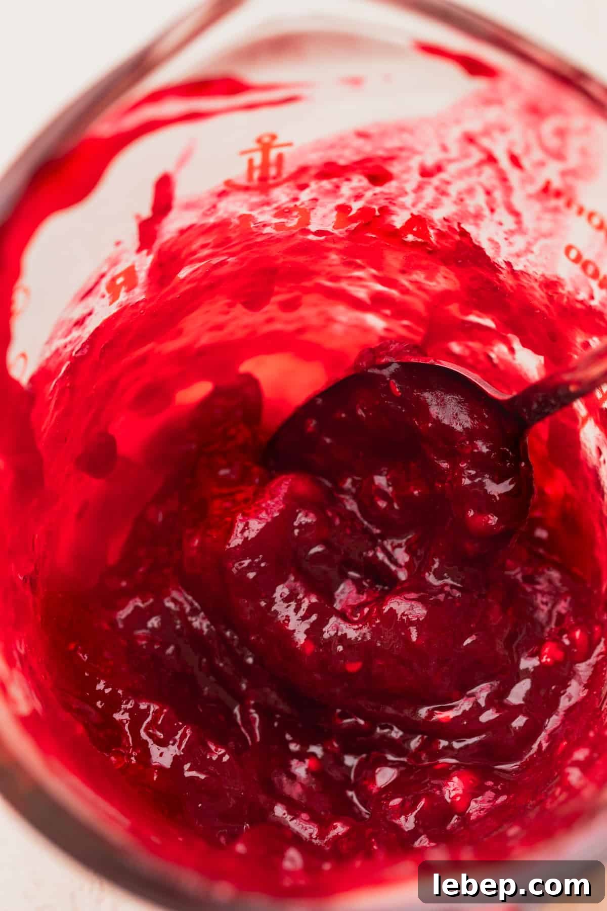 Raspberry jam in a measuring cup.