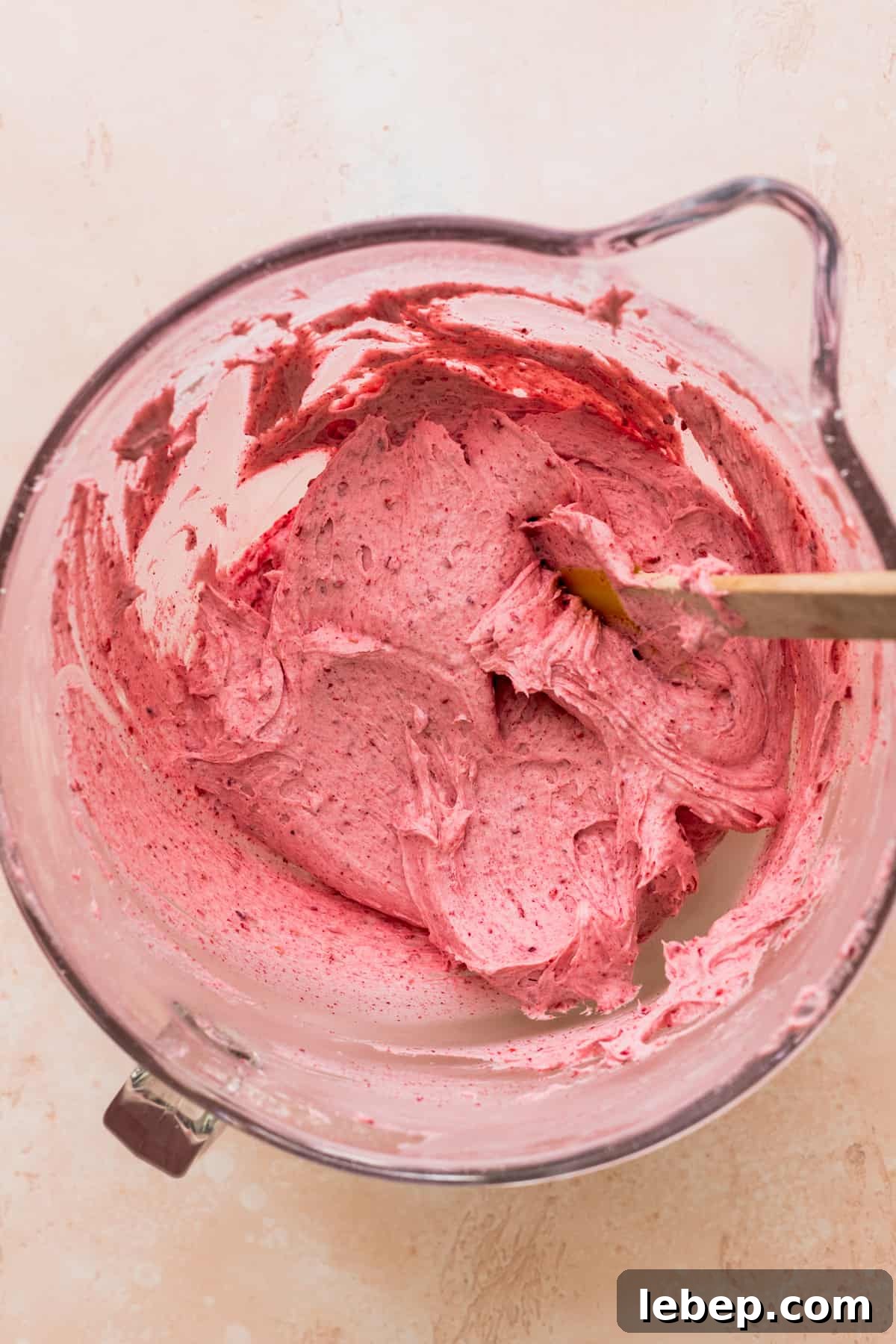 Raspberry frosting in a glass bowl.