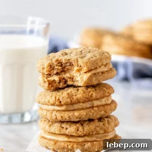 Stack of peanut butter sandwich cookies with glass of milk.