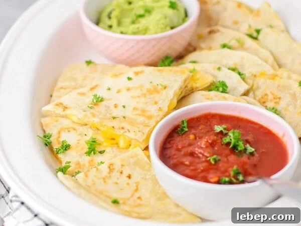 Walking Tacos: Portable Taco Cups for Parties and Snacks 4 A cheese quesadilla sliced into triangles and served with cups of red and green salsa.