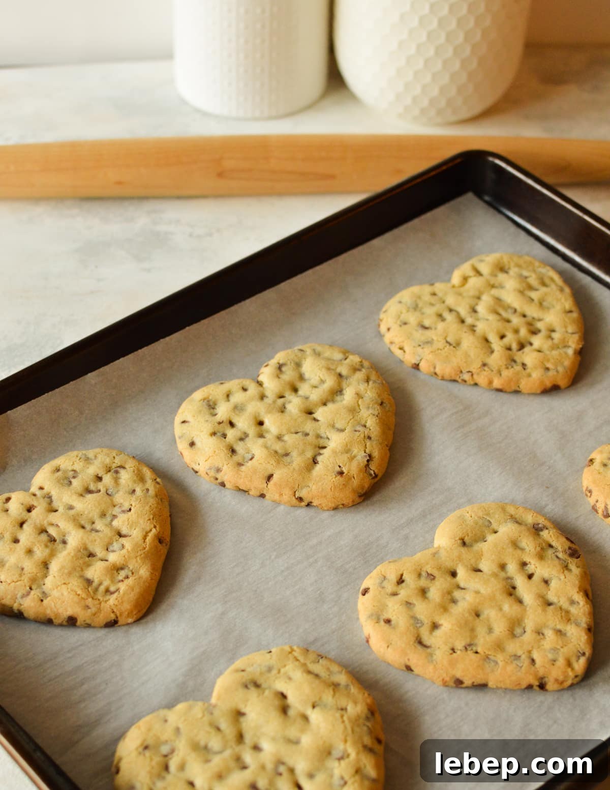 Heart-Shaped Chocolate Chip Cookies Recipe for Valentine Treats 9 chocolate chip heart cookies on sheet pan.