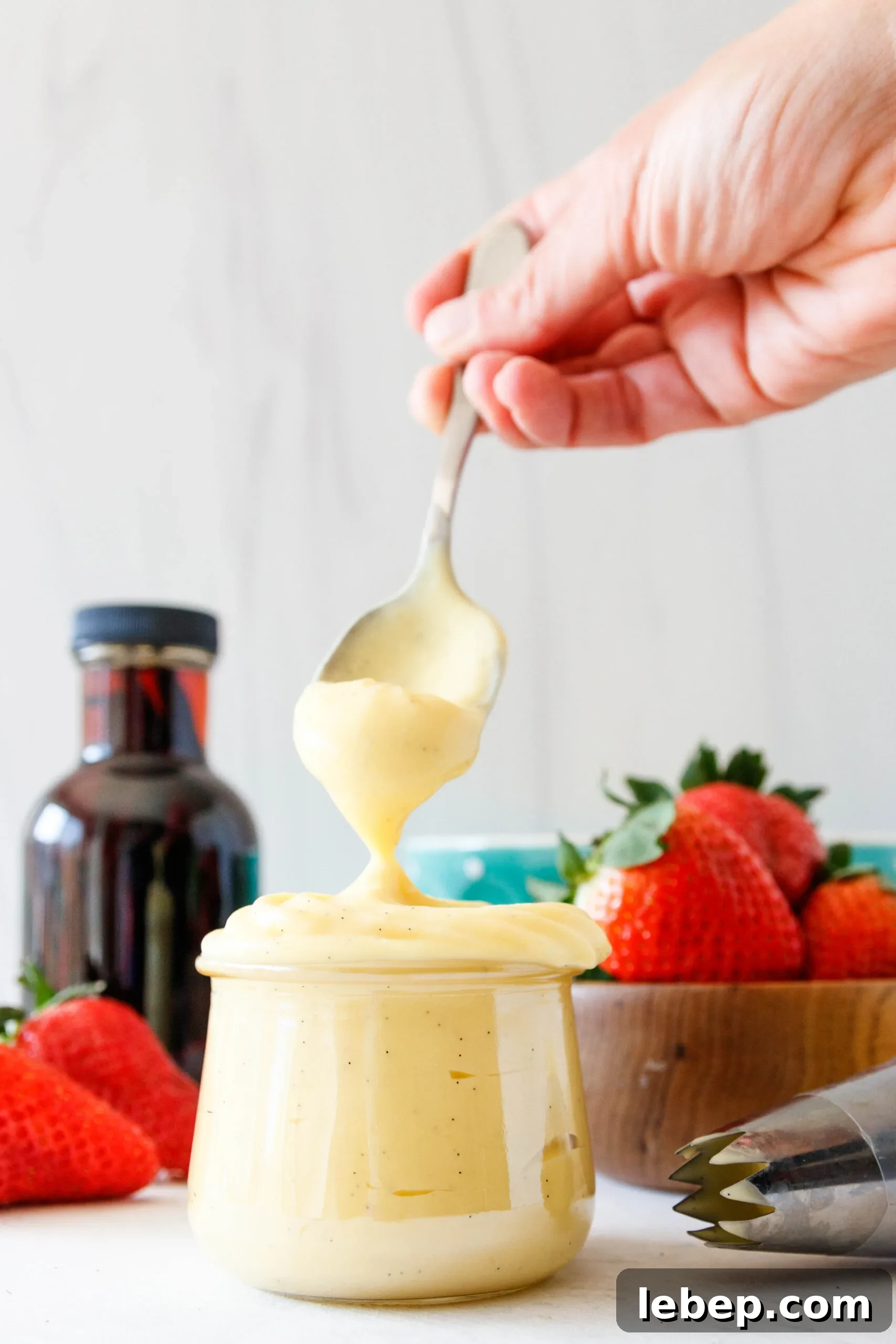 Classic Pastry Cream (Crème Pâtissière) Recipe for Desserts 6 spoon dipping into the jar of the pastry cream and lifting out to show texture