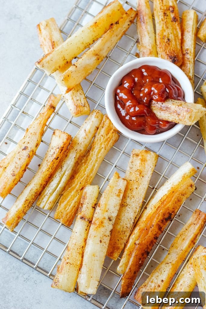 A small bowl with ketchup and slices of the yuca root baked and cooled in a cooling rack.