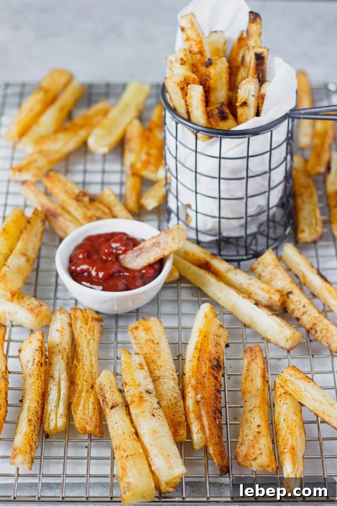 Baked slices of the yuca root in a cooling rack and a small container with dipping sauce