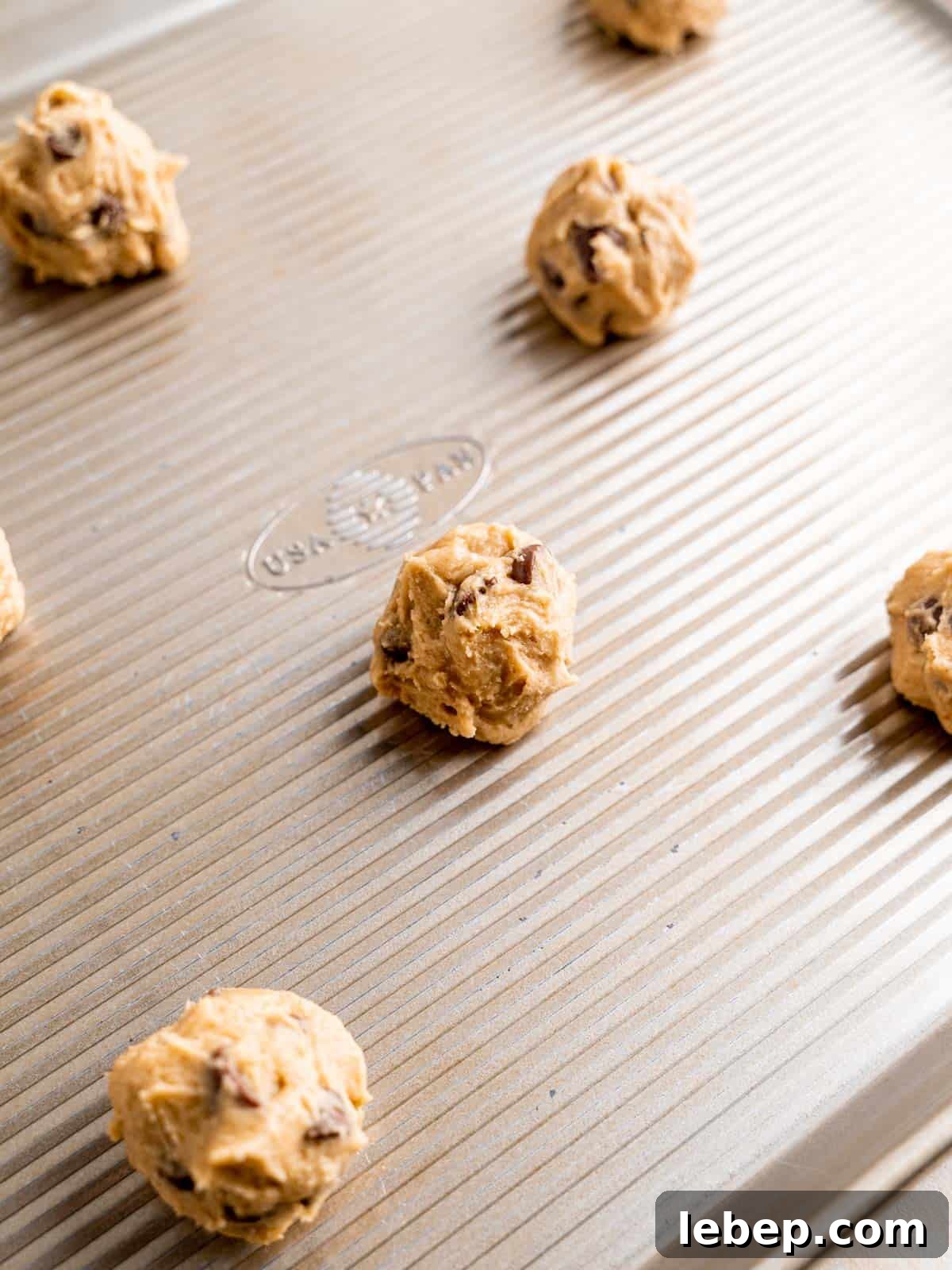 Chewy Malted Milk Chocolate Chip Cookie Recipe 6 Chocolate chip cookie dough balls on a baking sheet.