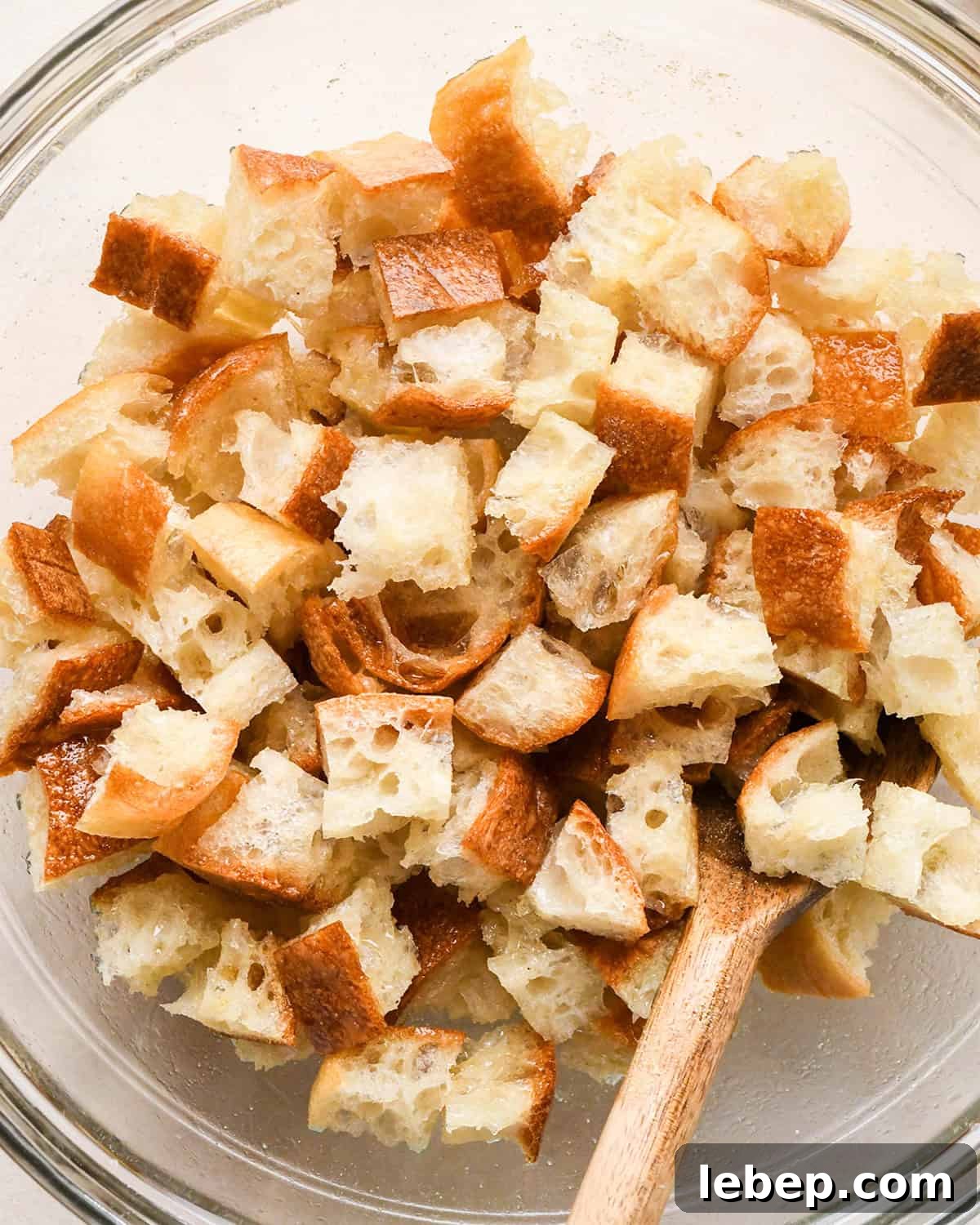 How to Make Croutons - stirring the croutons with a wooden spoon in a bowl