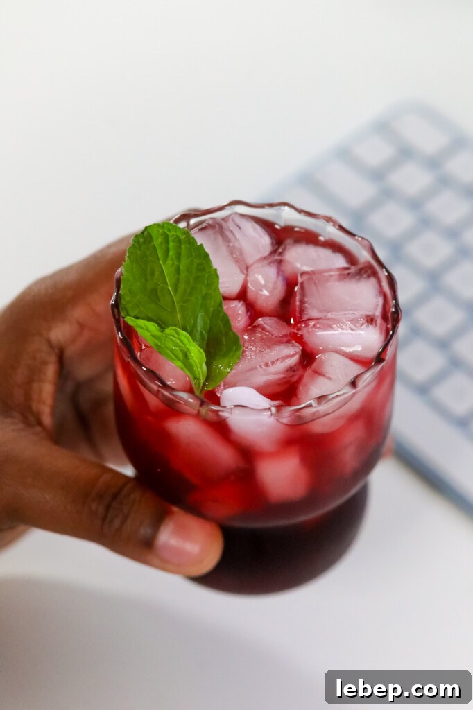 Sleepy Girl Mocktail Recipe: Relaxing Alcohol-Free Cocktail 3 a woman holding a wellness mocktail