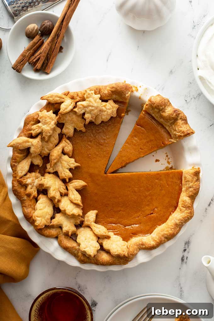 Top view of a pumpkin pie with a few slices cut.