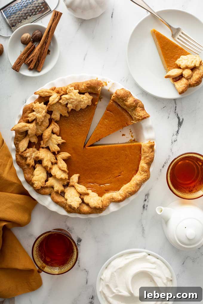 Top view of a full pie decorated with fall pastry leaves.