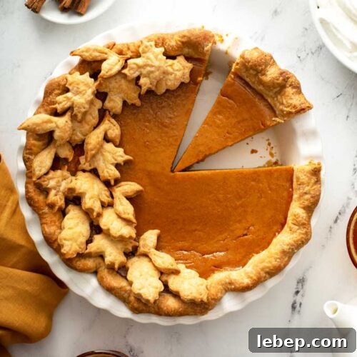 Top view of a pumpkin pie with a few slices cut.