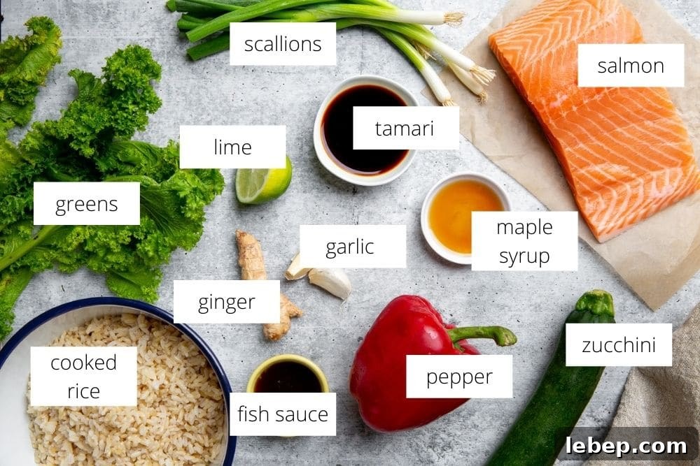 All of the ingredients for the salmon fried rice recipe arranged on a work surface and labeled. 