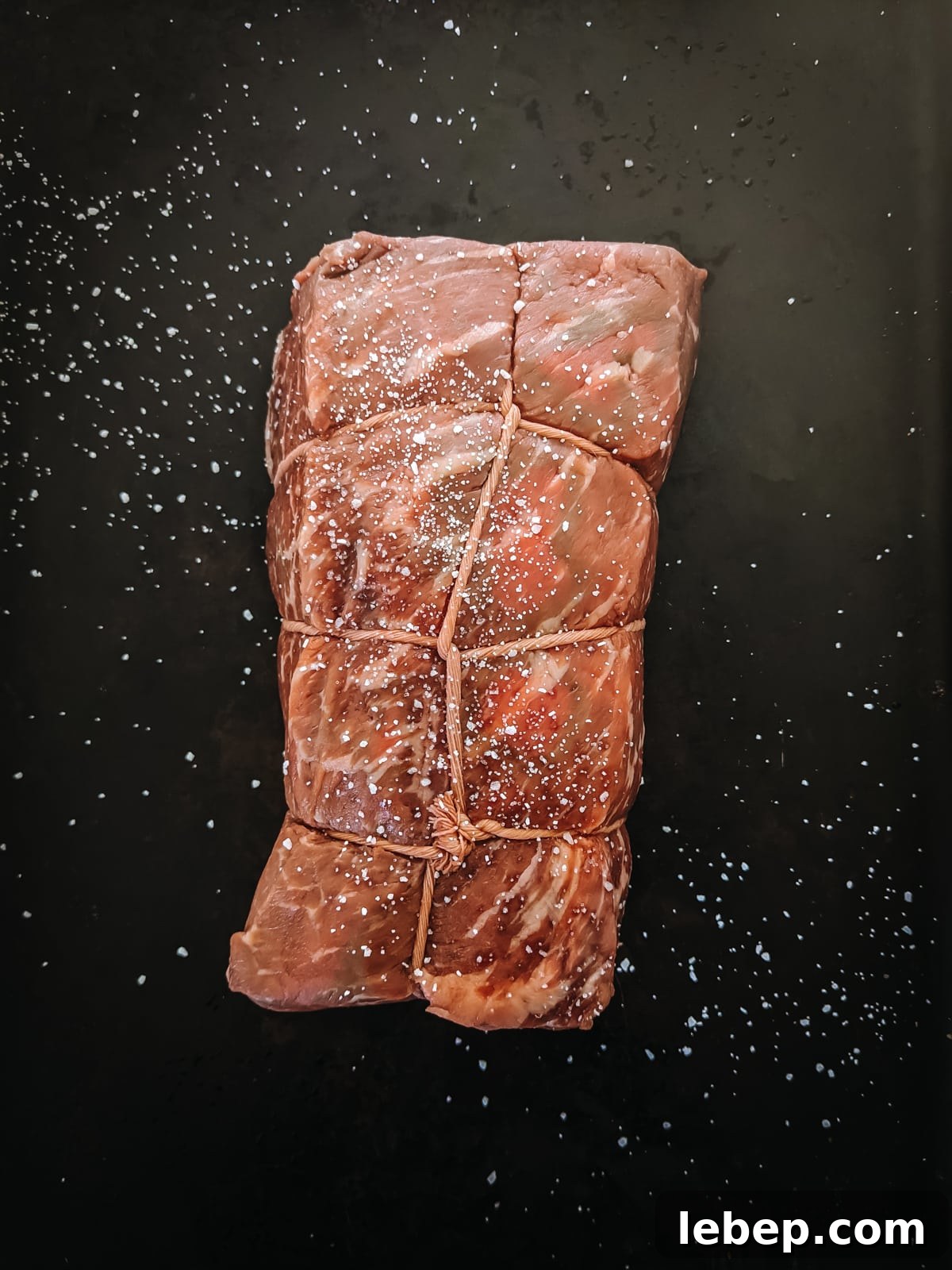 Tender Melt-in-Your-Mouth Eye of Round Roast Recipe 3 Raw eye of round roast seasoned with salt.