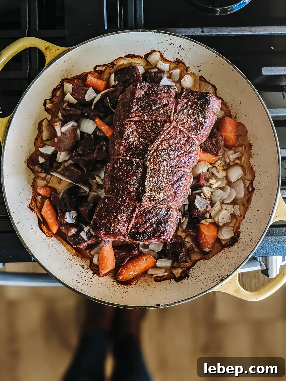 Tender Melt-in-Your-Mouth Eye of Round Roast Recipe 6 Roast taken out of the oven with browned veggies beneath it.