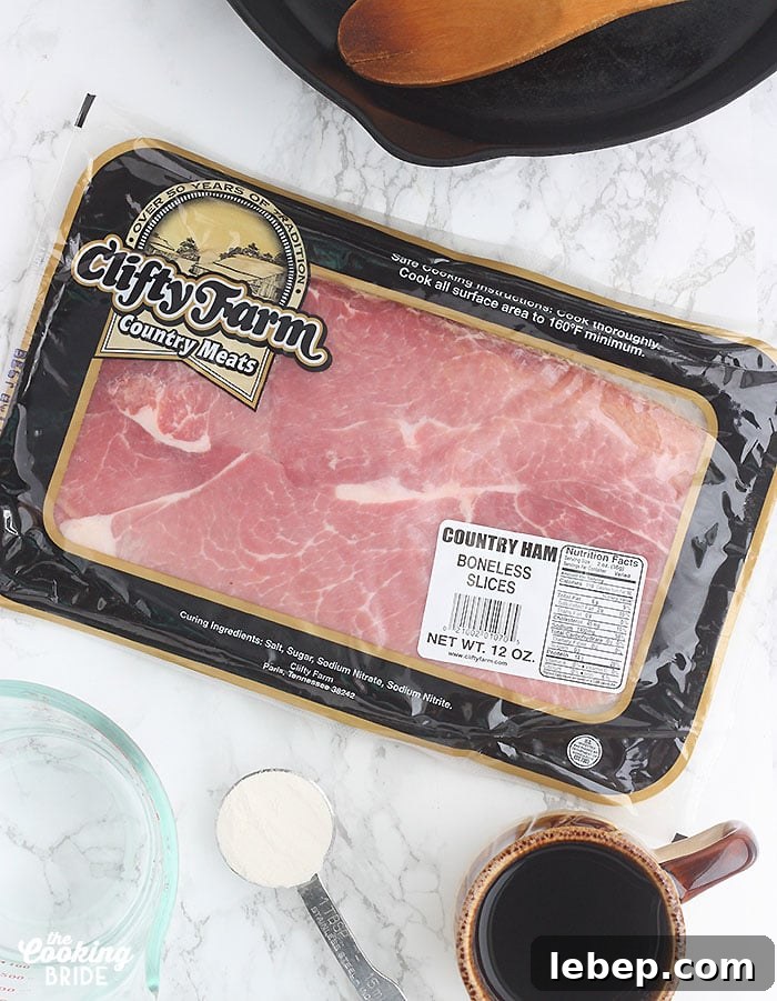 Southern Country Ham with Classic Red-Eye Gravy Recipe 3 package of Clifty Farm country ham on a marble counter surrounded by coffee water and a skillet