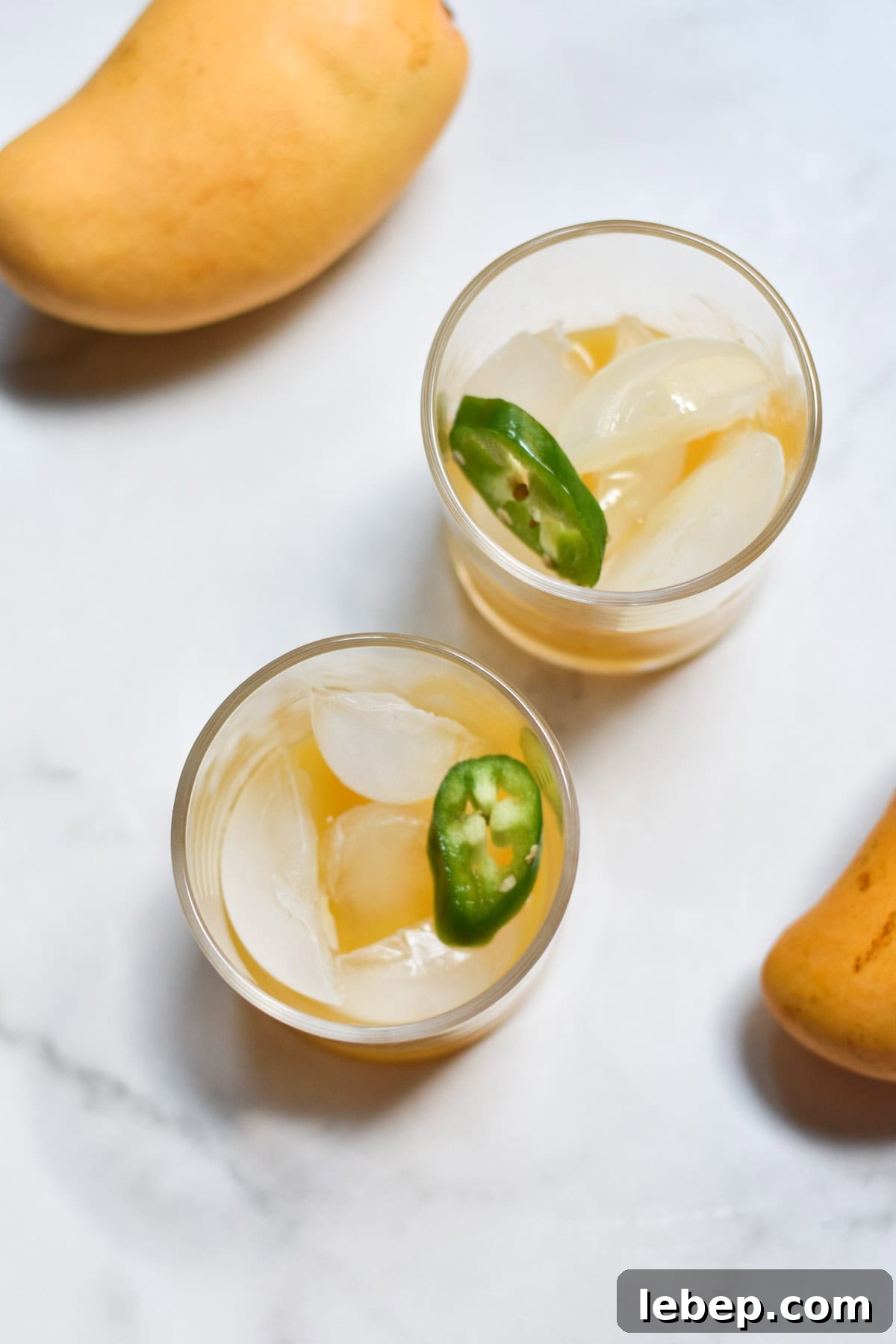 Filling a glass with ice, mango and lime juice.