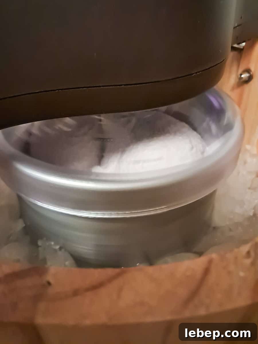 Creamy Amish Blackberry Ice Cream Recipe for Summer 9 churning homemade ice cream in an old-fashioned ice cream maker.