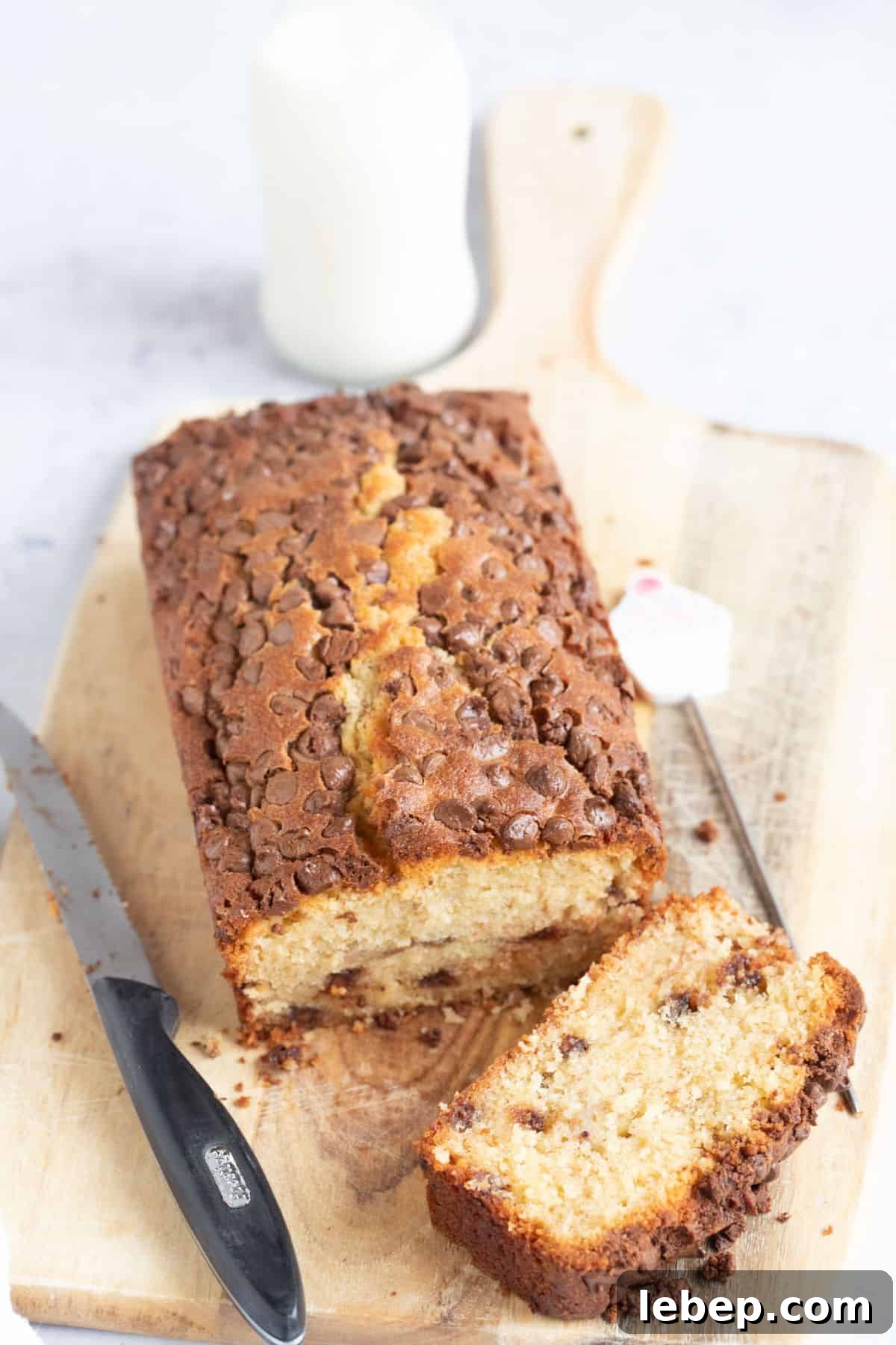 Air Fryer Banana Bread Recipe: Moist, Quick Loaf in 30 Minutes 2 Air fryer banana bread with milk chocolate chips on a wooden board.