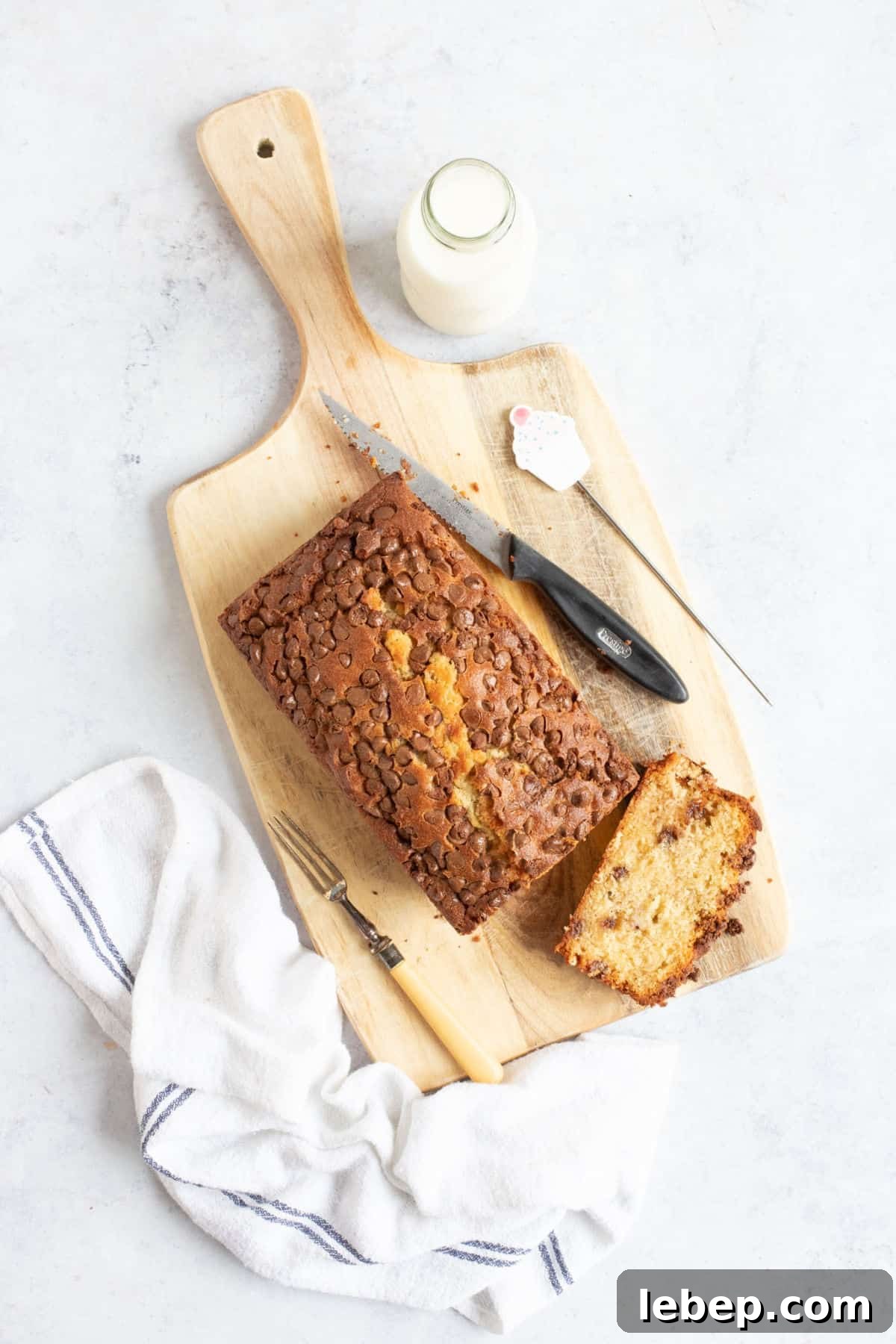 Air Fryer Banana Bread Recipe: Moist, Quick Loaf in 30 Minutes 13 Air fryer banana bread on a wooden board with a slice cut off.