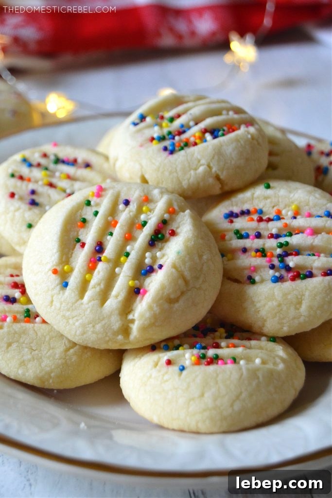 Closeup stack of whipped shortbread cookies on a white plate